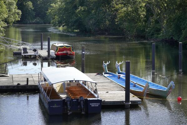 Boats rest on the Blackstone River, in Central Falls, R.I., Sunday, June 5, 2022. Environmental officials are urging residents to avoid a stretch of the Blackstone River after finding that sewage was leaking into the river from the Woonsocket Regional Wastewater Treatment Facility on Sunday. Residents are being advised to avoid swimming, boating or fishing in the river from Cumberland Hill Road, in Woonsocket, R.I., to the Slater Mill Dam, in Pawtucket, R.I. (AP Photo/Steven Senne)