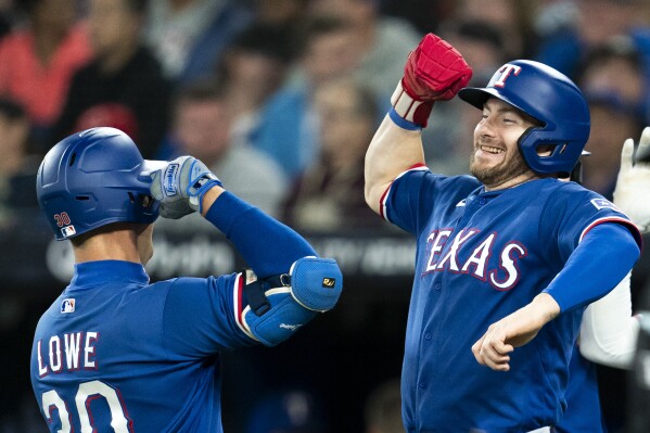 Texas Rangers' Nathaniel Lowe, left, celebrates his three-run home run against the Toronto Blue Jays with Robbie Grossman during the fourth inning of a baseball game Wednesday, Sept. 13, 2023, in Toronto. (Spencer Colby/The Canadian Press via AP)