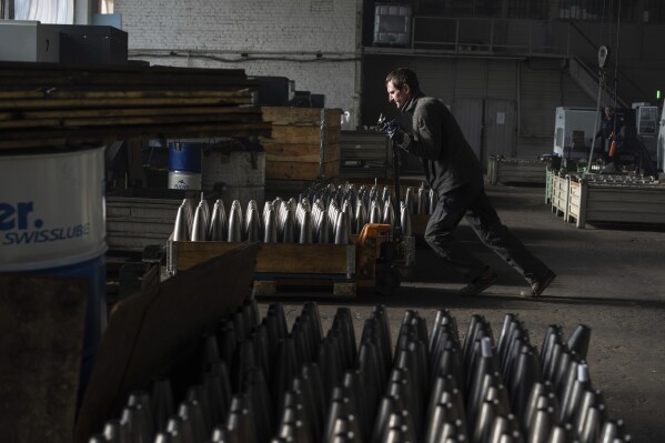 A worker hauls a cart with mortar shells at a factory in Ukraine, on Wednesday, January 31, 2024. (AP Photo/Evgeniy Maloletka)