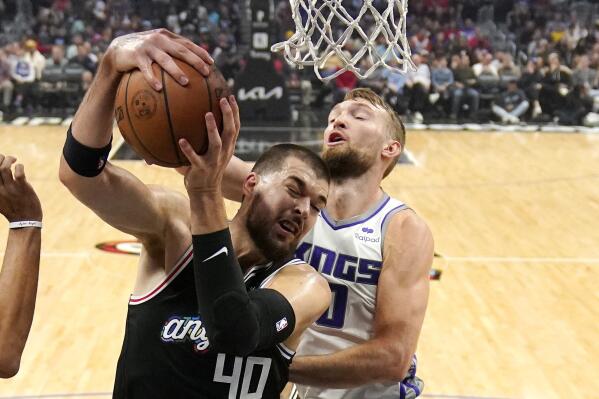 Los Angeles Clippers center Ivica Zubac, left, grabs a rebound away from Sacramento Kings forward Domantas Sabonis during the first half of an NBA basketball game Saturday, Dec. 3, 2022, in Los Angeles. (AP Photo/Mark J. Terrill)