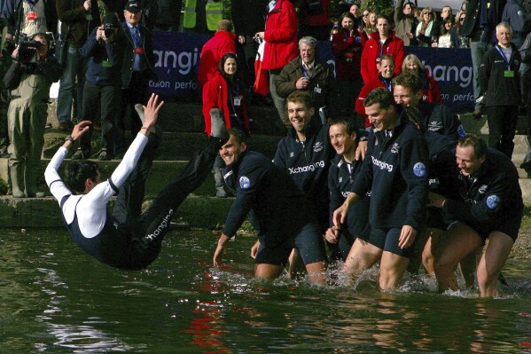 FILE - The Oxford crew, right, throw their cox Colin Groshong into the Thames at the 155th Boat Race, in London, Sunday March 29, 2009. Jumping into London’s River Thames has been the customary celebration for members of the winning crew in the annual Boat Race between storied English universities Oxford and Cambridge. Now researchers say it comes with a health warning. (AP Photo/Tom Hevezi, File)