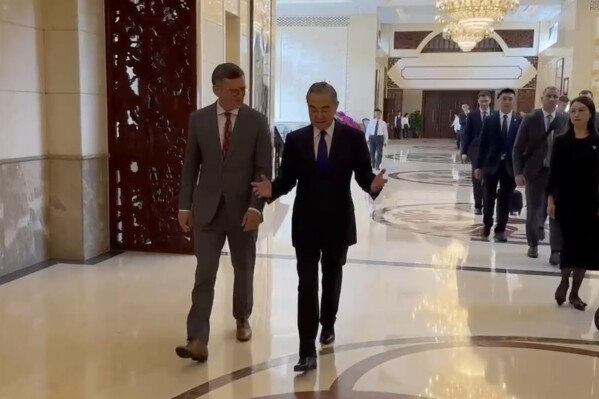 In this image taken from video released by the Ukraine Ministry of Foreign Affairs, Ukraine's Foreign Ministry Dmytro Kuleba, left walks with China's Foreign Minister Wang Yi before a meeting in the southern Chinese city of Guangzhou on Wednesday, July 24, 2024. Ukraine's foreign minister says he is seeking "common ground" in talks with his Chinese counterpart on ending his country's war with Russia. It is the first visit by a Ukrainian foreign minister since the war started in 2022. (Ukraine's Ministry of Foreign Affairs via ĢӰԺ)