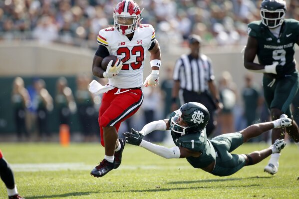 Maryland running back Colby McDonald (23) rushes against Michigan State defensive back Jaden Mangham (1) during the first half of an NCAA college football game, Saturday, Sept. 23, 2023, in East Lansing, Mich. (AP Photo/Al Goldis)