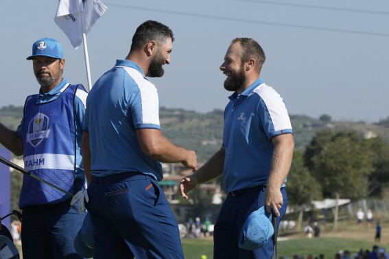Europe's Jon Rahm, left and playing partner Europe's Tyrrell Hatton celebrate on the 15th green after winning their morning Foursome match 4&3 at the Ryder Cup golf tournament at the Marco Simone Golf Club in Guidonia Montecelio, Italy, Friday, Sept. 29, 2023. (AP Photo/Alessandra Tarantino)