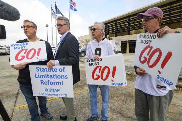 FILE - Members of SNAP, the Survivors Network of those Abused by Priests, including, from left, Kevin Bourgeois, John Gianoli, Richard Windmann and John Anderson, hold signs during a conference in front of the New Orleans Saints training facility, Jan. 29, 2020, in Metairie, La. Louisiana’s Supreme Court agreed Friday, May 10, 2024, to reconsider its recent ruling that wiped out a state law giving adult victims of childhood sexual abuse a renewed opportunity to file damage lawsuits. (AP Photo/Matthew Hinton, File)