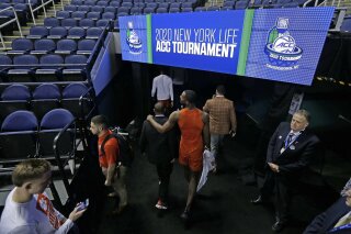 Clemson players leave the floor after the NCAA college basketball games at the Atlantic Coast Conference tournament were canceled due to concerns over the coronavirus in Greensboro, N.C., Thursday, March 12, 2020. (AP Photo/Gerry Broome)