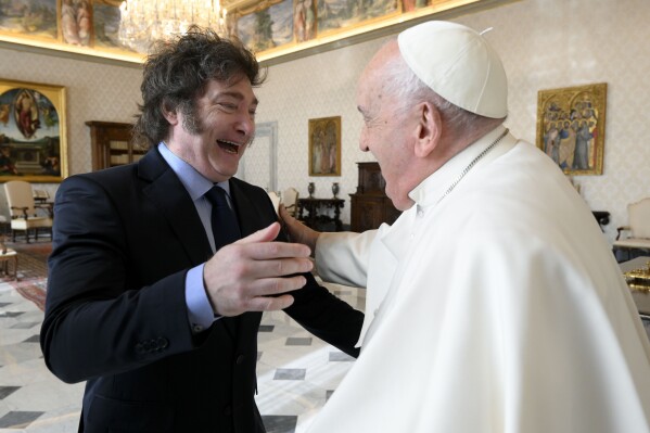 In this image distributed by Vatican Media, Argentine President Javier Milei, left, cheers at Pope Francis as they meet in the pontiff's studio at The Vatican for a private audience, Monday, Feb. 12, 2024. Milei, who will meet Italian President Sergio Mattarella and Italian Premier Giorgia Meloni later in the day, attended the canonization of the first Argentine female saint, María Antonia de Paz y Figueroa also known as "Mama Antula" in St. Peter's Basilica on Sunday. (Vatican Media via AP, HO)