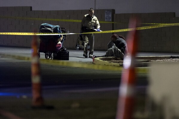 The Metropolitan Police investigate the scene of a shooting in Las Vegas, Friday, Dec. 1, 2023.  Five homeless people were shot Friday, one of whom died, and police are searching for a lone suspect, authorities said.  (Ellen Schmidt/Las Vegas Review-Journal via AP)