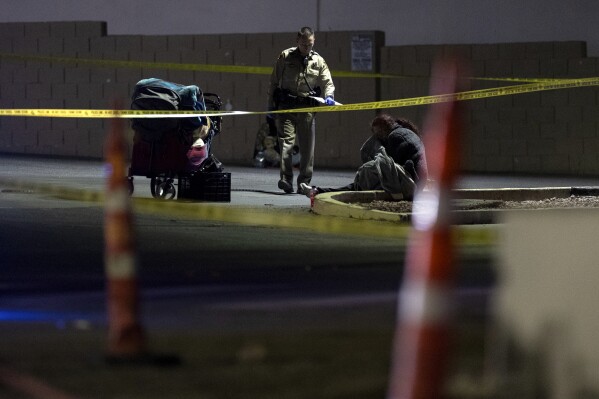 Metropolitan police investigate the scene of a shooting on Friday, Dec. 1, 2023, in Las Vegas. Five homeless people were shot, Friday, one of them fatally, and police were searching for a lone suspect, authorities said. (Ellen Schmidt /Las Vegas Review-Journal via AP)
