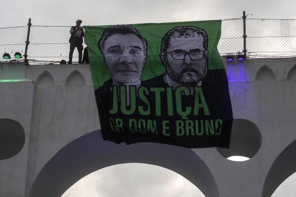 FILE - A sign that reads in Portuguese "Justice for Dom and Bruno" and with images of the British journalist Dom Phillips, on the left, and the indigenous specialist Bruno Pereira is displayed on the Arcos da Lapa aqueduct during a protest by environmental groups in Rio de Janeiro, Brazil, June 26, 2022. Brazilian police said Monday, Jan. 23, 2023, they planned to indict Ruben Dario da Silva Villar, a Colombian fish trader, as the mastermind of murders. (AP Photo/Bruna Prado, File)