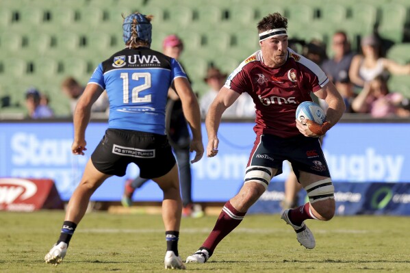 Ryan Smith of the Queensland Reds, right, tries to avoid defense by the Western Force during the Super Rugby Pacific Round 5 match in Perth, Australia, Saturday, March 23, 2024. (Richard Wainwright/AAP via AP)