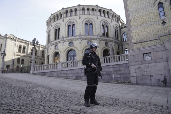 A police officer stands guard outside the Norwegian Parliament building in Oslo, Wednesday, April 3, 2024. Two bomb threats led to the shutting down of the Norwegian parliament, although the assembly was not evacuated, and lawmakers continued to debate. (Cornelius Poppe/NTB Scanpix via AP)