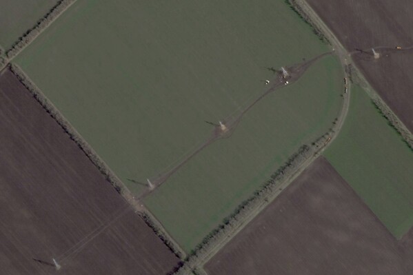 This satellite photo from Planet Labs PBC shows Russian workers building pylons for electrical transmission lines in occupied territory just west of Mariupol, Ukraine, April 15, 2025. (Planet Labs PBC via AP)