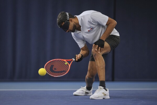 Blind tennis champion Naqi Rizvi plays a shot during a visually impaired tennis training session in London, Tuesday, May 20, 2025. (AP Photo/Kin Cheung)