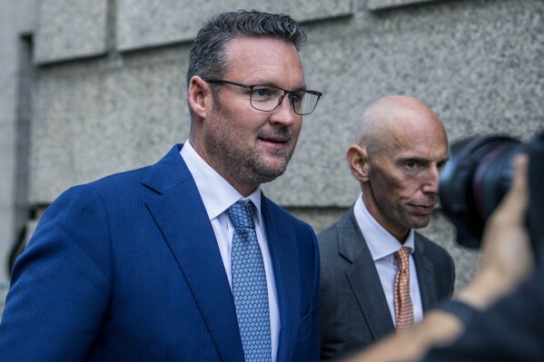 FILE - Trevor Milton, left, leaves the Thurgood Marshall United States Courthouse, Sept. 12, 2022, in New York. In a filing late Tuesday, Nov. 14, 2023, lawyers for Milton, the founder of truck maker Nikola Corp., said he should not face incarceration because his fraud conviction is nothing like the fraud that landed Theranos founder Elizabeth Holmes in prison. (AP Photo/Brittainy Newman, File)