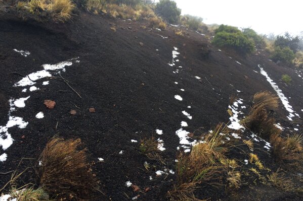
              Black volcanic cinders have a dusting of snow at the Polipoli State Recreation area on the slopes of Haleakala near Kula on the Hawaii island of Maui, Monday, Feb. 11, 2019. A strong storm hitting Hawaii has knocked out power, brought down tree branches, flooded coastal roads — and even brought snow. Snow is not unheard of in mountainous parts of the tropical island chain, but officials say the coating at 6,200 feet (1,900 meters) at the state park on Maui could mark the lowest-elevation snowfall ever recorded in the state. (Brent Edwards via AP)
            