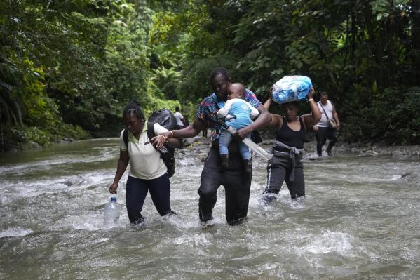 FILE - Haitian migrants wade through a river as they cross the Darien Gap, from Colombia into Panama, hoping to reach the U.S., Oct. 15, 2022. United States forces will assist their Colombian and Panamanian counterparts with intelligence gathering to dismantle smuggling rings operating in the dense jungle of the Darien Gap, a key route for migrants heading to the U.S. from South America, a senior Biden administration official said Wednesday, April 12, 2023. (AP Photo/Fernando Vergara, File)