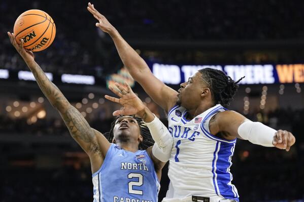 North Carolina's Caleb Love (2) shoots over the reach of Duke's Trevor Keels (1) during the first half of a college basketball game in the semifinal round of the Men's Final Four NCAA tournament, Saturday, April 2, 2022, in New Orleans. (AP Photo/David J. Phillip)