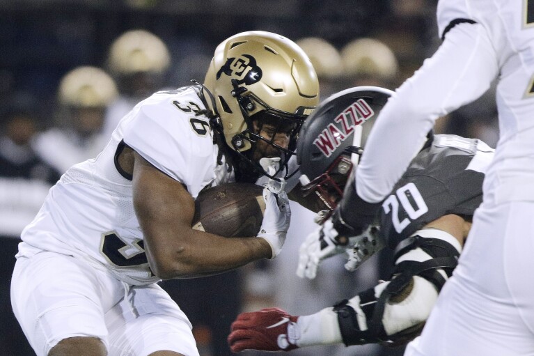 Colorado running back Seavion Wilkerson, 36, tries to pass Washington State defensive end Quinn Roof, 20, during the first half of an NCAA college football game Friday, Nov. 17, 2023, in Pullman, Wash. (AP Photo/Young Kwak)