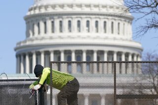 A worker removes razor wire from a security fence on Capitol Hill in Washington, Saturday, March 20, 2021. (AP Photo/Patrick Semansky)