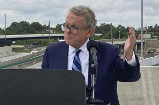 FILE - In this July 13, 2021 file photo, Ohio Gov. Mike DeWine promotes a new entrance ramp onto I-70 in downtown Columbus, Ohio. DeWine signed into law a map of new congressional districts on Saturday, Nov. 20, despite objections from Democrats and voting rights groups. The map will be in effect for the next four years. (AP Photo/Andrew Welsh-Huggins, File)