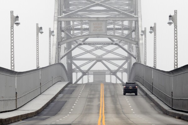 FILE - A lone vehicle leaves Cape Cod over the usually busy Bourne Bridge, May 25, 2020, in Bourne, Mass. Massachusetts is making headway on putting together the funding needed to replace the two aging bridges that connect Cape Cod to the rest of the state. Gov. Healey announced Friday, July 12, 2024 that the Massachusetts Department of Transportation and U.S. Army Corps of Engineers have secured nearly $1 billion in additional federal dollars for the construction of the replacement spans. (AP Photo/Michael Dwyer, File)