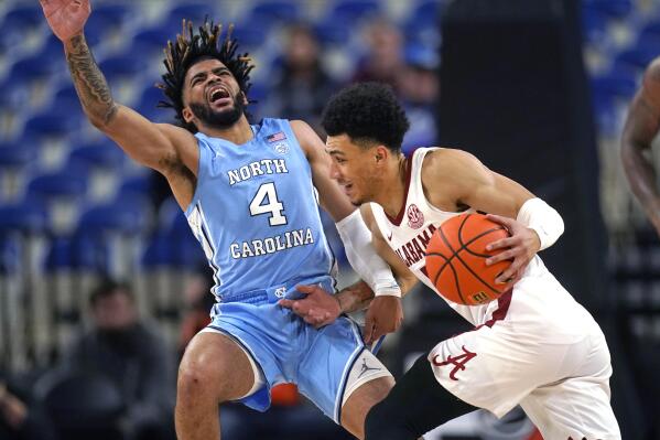North Carolina guard R.J. Davis (4) fouls Alabama guard Jahvon Quinerly during the first half of an NCAA college basketball game in the Phil Knight Invitational on Sunday, Nov. 27, 2022, in Portland, Ore. (AP Photo/Rick Bowmer)
