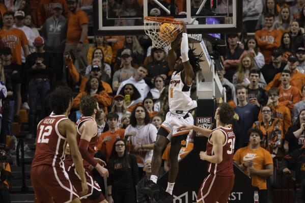 Oklahoma State's Caleb Asberry (5) slam dunks the ball during the second half of the NCAA college basketball game against Oklahoma in Stillwater, Okla., Wednesday, Jan. 18, 2023. (AP Photo/Mitch Alcala)