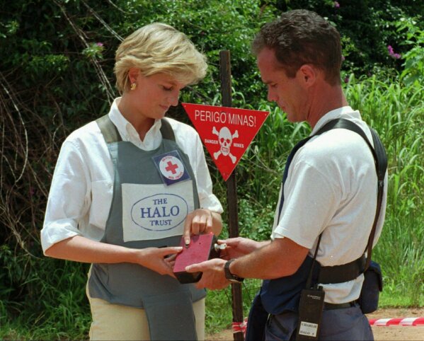 FILE - In this Jan. 15, 1997 file photo, Britain's Princess Diana uses a remote switch to trigger the detonation of some explosive ordinance dug up by mine sweepers in Huambo, Angola. Prince Harry on Friday Sept. 27, 2019, is following in the footsteps of his late mother, Princess Diana, whose walk through an active mine field in Angola years ago helped to lead to a global ban on the deadly weapons. (AP Photo/Giovanni Diffidenti, File)