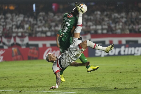 Luciano of Brazil's Sao Paulo, bottom, and Rodrigo Sandoval of Chile's Cobresal battle for the ball during a Copa Libertadores Group B soccer match at Morumbi stadium in Sao Paulo, Brazil, Wednesday, April 10, 2024. (AP Photo/Andre Penner)