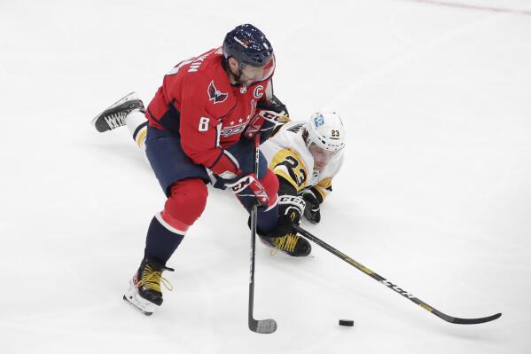 Washington Capitals' Alex Ovechkin (8) and Pittsburgh Penguins' Brock McGinn (23) battle for the puck during the second period of an NHL hockey game, Sunday, Nov. 14, 2021, in Washington. (AP Photo/Luis M. Alvarez)