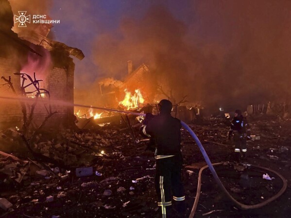 In this photo provided by the Ukrainian Emergency Service, firefighters try to put out a fire following a Russian attack in Kyiv region, Ukraine, Sunday, May 25, 2025. (Ukrainian Emergency Service via AP)