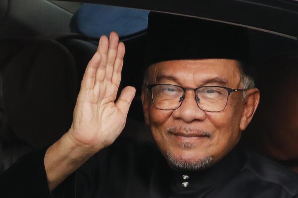 Malaysia's newly appointed Prime Minister Anwar Ibrahim waves to media as he arrives at National Place in Kuala Lumpur, Malaysia, Thursday, Nov. 24, 2022. Malaysia’s king on Thursday named Anwar as the country’s prime minister, ending days of uncertainty after the divisive general election produced a hung Parliament. (Fazry Ismail/Pool Photo via AP)