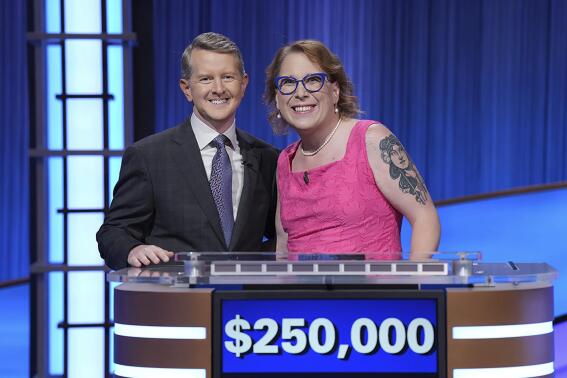 In this undated photo provided by Jeopardy Productions, Inc., "Jeopardy!" host Ken Jennings, left, poses with contestant Amy Schneider. Schneider capped her big year by winning a hard-fought “Jeopardy!” tournament of champions in an episode that aired Monday, Nov. 21, 2022. (Tyler Golden/Sony Pictures Television/Courtesy of Jeopardy Productions, Inc. via AP)