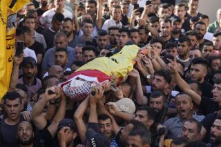 Palestinian mourners carry the body of Kamel Alawnah, who was shot by Israeli forces a day earlier, according to the Palestinian Ministry of Health, in the village of Jaba, near the West Bank city of Jenin, Sunday, July 3, 2022. The Israeli Defense Forces say a suspect hurled a Molotov cocktail at IDF soldiers in Jaba, who responded with live fire.  (AP Photo/Majdi Mohammed)