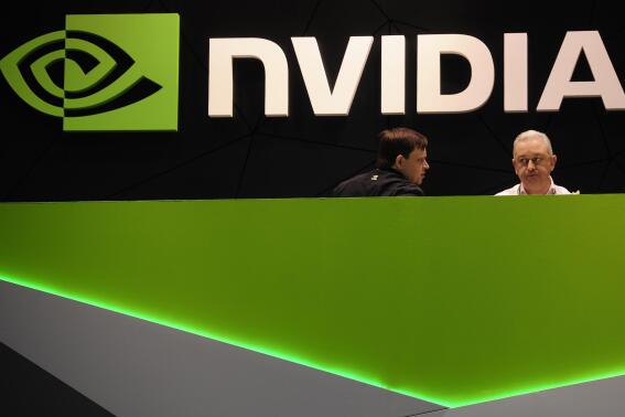 FILE - People gather in the Nvidia booth at the Mobile World Congress mobile phone trade show Thursday, Feb. 27, 2014 in Barcelona, Spain. The Federal Trade Commission on Thursday, Dec. 2, 2021 sued to block graphics chip maker Nvidia’s $40 billion purchase of chip designer Arm, saying the deal would create a powerful company that could hurt the growth of new technologies.  (AP Photo/Manu Fernandez, File)