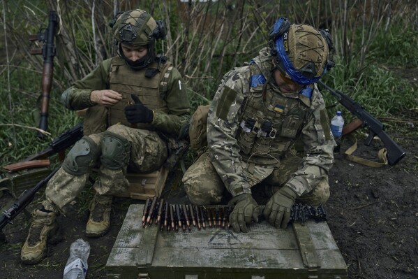 FILE - Ukrainian soldiers prepare their ammunition at the frontline positions near Vuhledar, Donetsk region, Ukraine, on May 1, 2023. Two years after Russia’s full-scale invasion captured nearly a quarter of the country, the stakes could not be higher for Kyiv. After a string of victories in the first year of the war, fortunes have turned for the Ukrainian military, which is dug in, outgunned and outnumbered against a more powerful opponent. (AP Photo/Libkos, File)