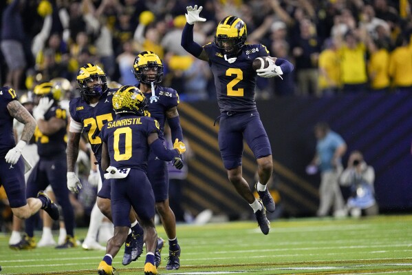 Michigan defensive back Will Johnson celebrates after an interception against Washington during the second half of the national championship NCAA College Football Playoff game Monday, Jan. 8, 2024, in Houston. (AP Photo/David J. Phillip)