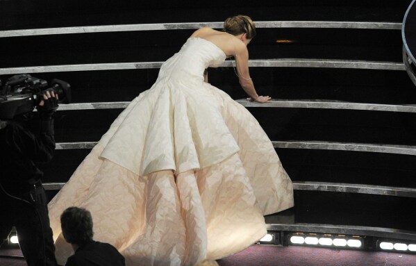 Jennifer Lawrence stumbles as she walks on stage to accept the award for best actress in a leading role for "Silver Linings Playbook" during the Oscars at the Dolby Theatre on Sunday Feb. 24, 2013, in Los Angeles.  (Photo by Chris Pizzello/Invision/AP)