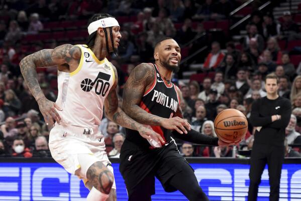 Portland Trail Blazers guard Damian Lillard, right, drives to the basket on Utah Jazz guard Jordan Clarkson, left, during the first half of an NBA basketball game in Portland, Ore., Wednesday, Jan. 25, 2023. (AP Photo/Steve Dykes)
