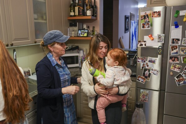Hazel Brief looks at her daughter and granddaughter at their home in Modiin, Israel, Dec. 8, 2024. Hazel's son Yona Brief has died 14 months after Hamas militants shot him 14 times on Oct. 7, 2024 in Kfar Aza, (AP Photo/Sam McNeil)