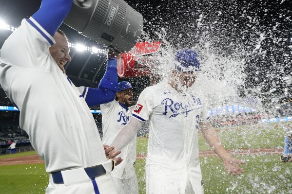Kansas City Royals' Vinnie Pasquantino, right, is doused by Bobby Witt Jr., left, and MJ Melendez after the Royals defeated the Houston Astros 11-2 in a baseball game Wednesday, April 10, 2024, in Kansas City, Mo. (AP Photo/Ed Zurga)
