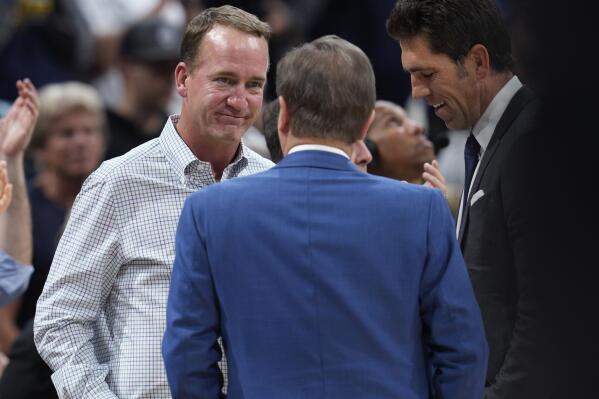 Former NFL quarterback Peyton Manning, left, chats with Joe Lacob, majority owner of the Golden State Warriors, during a timeout in the second half of Game 3 of an NBA basketball first-round Western Conference playoff series between the Warriors and the Denver Nuggets on Thursday, April 21, 2022, in Denver. (AP Photo/David Zalubowski)