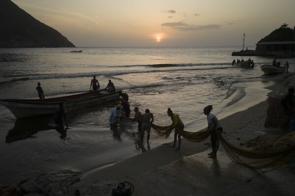 Fisherwoman Maria Reyes and her crew pull a net to place it on the beach after a day of fishing, in Chuao, Venezuela, Thursday, June 8, 2023. Once relegated to cooking or cleaning at hostels, bed-and-breakfasts and diners, women in the coastal communities of Choroni and neighboring Chuao have been working alongside men to catch thousands of pounds of fish a day. (AP Photo/Matias Delacroix)