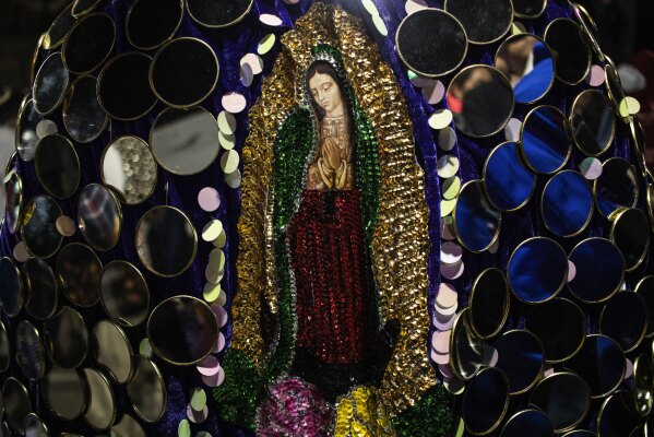 A man wears a costume featuring an image of the Virgin of Guadalupe during a Muerteada parade in San Jose, Mexico, Thursday, Nov. 2, 2023. Mexicans in the Oaxacan town celebrate the traditional Muerteada, a theatrical recreation that is performed through the night of November 1 until the early morning of the following day, with dances and music parading through the streets, while telling the story of how a deceased person is resurrected with the help of a priest, a doctor and a spiritist. (AP Photo/Maria Alferez)