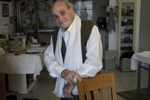 Gad Partok, 93, a Tunisian-born Holocaust survivor, poses for a portrait in his home in Ashkelon, southern Israel, Friday, Jan. 26, 2024. He never thought he'd have to relive the horrors of the Nazi onslaught that claimed the lives of his father and two brothers. Then, on Oct. 7, he watched on TV from his living room as Israeli news channels played videos of Hamas militants tearing through communities just a few kilometers (miles) from where he lives. He took cover as rocket fire from Gaza pounded Ashkelon, the southern Israeli city he moved to after emigrating from Tunisia in 1947 (AP Photo/Maya Alleruzzo)