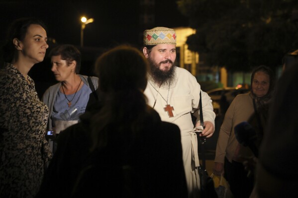 A priest from Romania among the first group of Bulgarian citizens evacuated from Israel, along with dozens of foreign nationals from Slovenia, the U.S., Belgium, Albania, Kosovo and Romania, arrives at Vassil Levsky airport in Sofia, Wednesday, June 18, 2025. (AP Photo/Valentina Petrova)