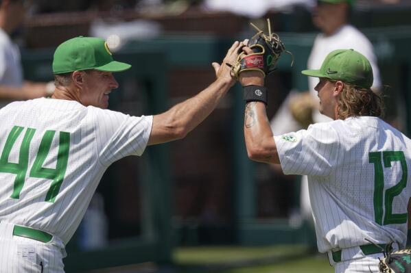 Oregon head coach Mark Wasikowski congratulates pitcher Matt Dallas (12) as he comes off the field after pitching against Xavier during the eighth inning of an NCAA college baseball tournament regional game Friday, June 2, 2023, in Nashville, Tenn. (AP Photo/George Walker IV)