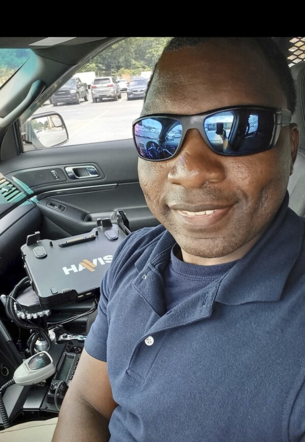 In this photo provided by Sharline Volcy, Ronald Donat poses for a selfie in a squad car after he was hired by the Gwinnett County Police Department in 2021. (Sharline Volcy via AP, File)