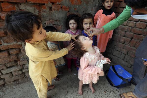 A health worker administers a polio vaccine to a child in Lahore, Pakistan, Monday, Feb. 28, 2022. (AP Photo/K.M. Chaudary)